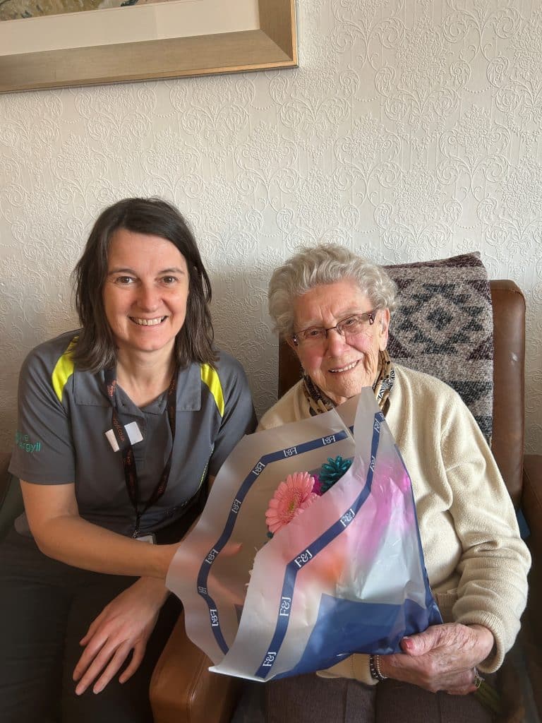 Youth Worker Ann Kennovin presents Jessie with a card and a bouquet of flowers on behalf of the young people
